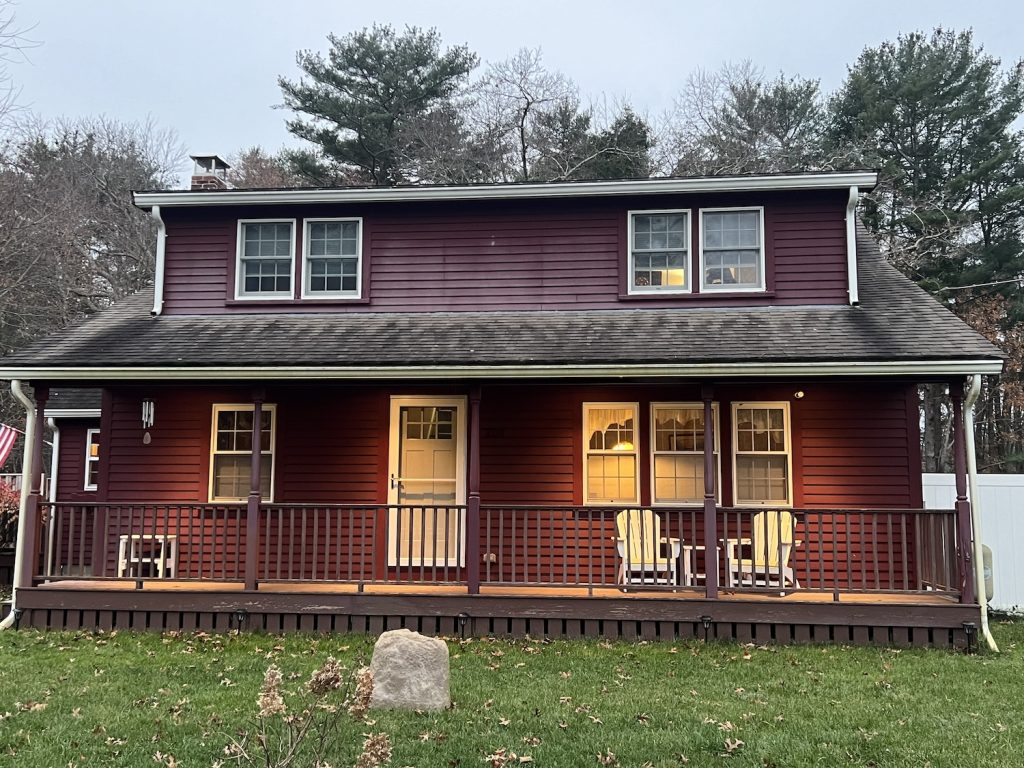 Front of home with red siding and porch